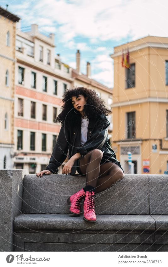 Pretty woman sitting on fence Woman Attractive City fashionable Curly Brunette Jacket Fence Fashion Youth (Young adults) Beautiful pretty Street Model Style