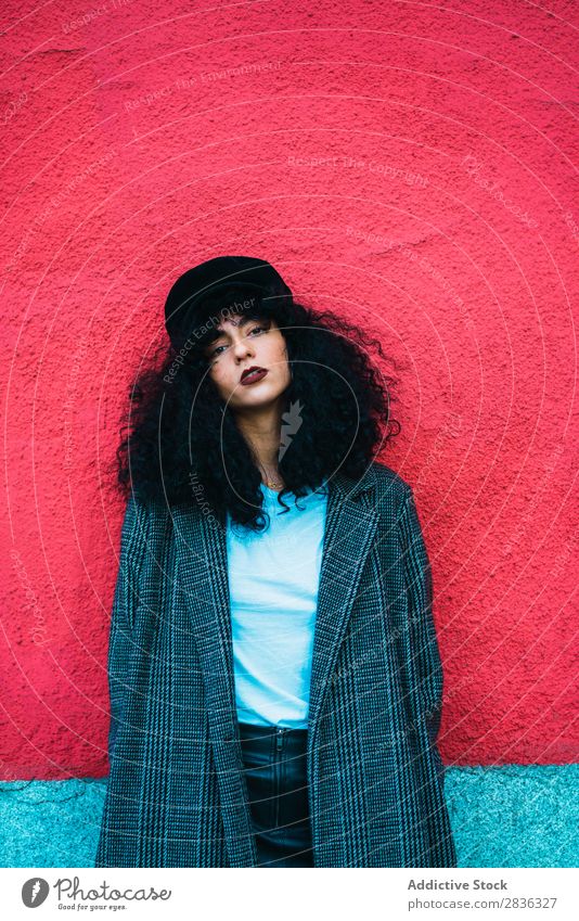 Stylish curly woman at colorful wall Woman Attractive City fashionable Curly Brunette Wall (building) Multicoloured Red Bright Looking into the camera Coat