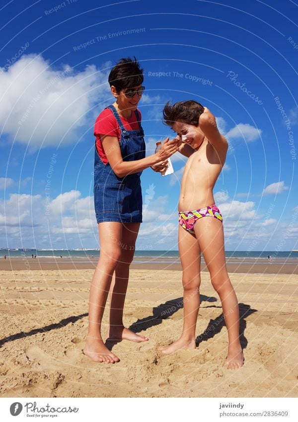 Mother throwing sunscreen on her little daughter on a tropical beach Lifestyle Joy Happy Beautiful Cream Leisure and hobbies Vacation & Travel Summer Sun Beach