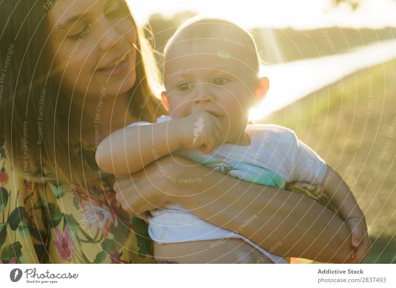 Mother holding kid on hands in park Child Park Sunbeam Family & Relations Happy Human being Woman Happiness Summer Lifestyle Love Parents Nature