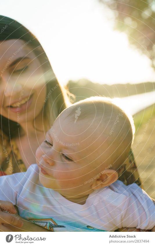 Mother holding kid on hands in park Child Park Sunbeam Family & Relations Happy Human being Woman Happiness Summer Lifestyle Love Parents Nature