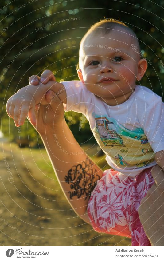 Mother holding kid on hands in park Child Park Sunbeam Family & Relations Happy Human being Woman Happiness Summer Lifestyle Love Parents Nature