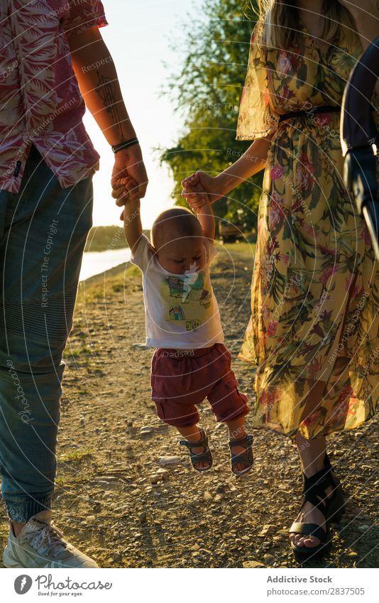 Happy family with child Mother Child Park Green Carrying Sunbeam Human being Woman Happiness Summer Lifestyle Love same gender parents Homosexual Couple