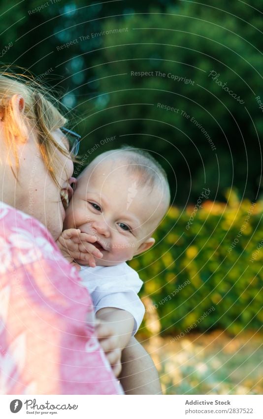 Mother holding kid on hands in park Child Park Sunbeam Family & Relations Happy Human being Woman Happiness Summer Lifestyle Love Parents Nature