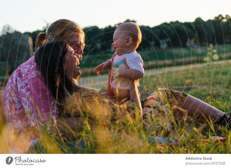 Happy lesbian family with child Mother Child Park Lawn Green Sunbeam Human being Woman Happiness Summer Lifestyle Love same gender parents Homosexual Couple