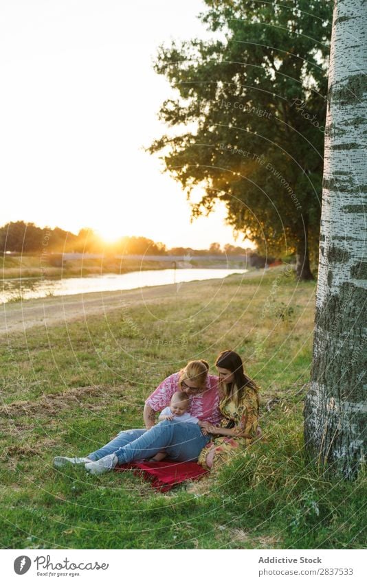 Lesbian family with child on lawn Mother Child Park Lawn Green Sunbeam Happy Human being Woman Happiness Summer Lifestyle Love same gender parents Homosexual