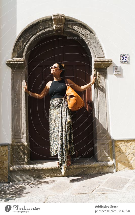 Stylish traveler posing in doorway Woman Traveling Street To enjoy romantic Happiness enjoying enjoyment Summer Relaxation City Town Historic Beautiful Posture