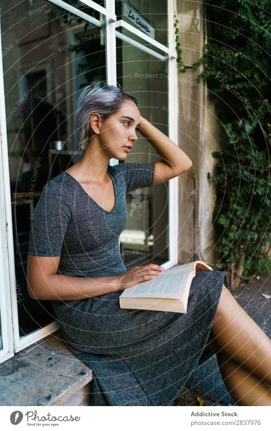 Woman reading book at window Book Street Sit Window Windowsill Beautiful Girl Youth (Young adults) Student pretty Adults Smiling City Beauty Photography