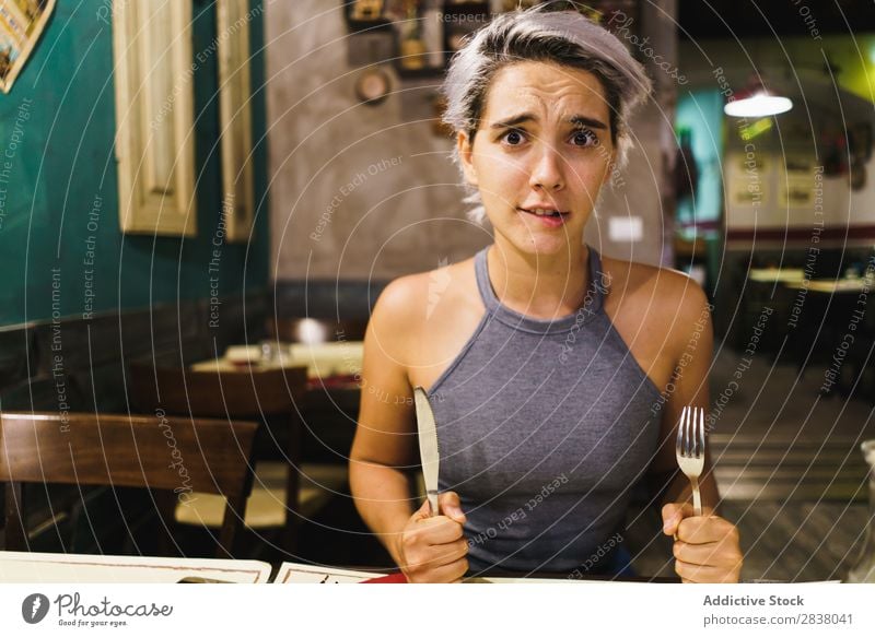 Furious girl posing with silverware Woman Restaurant Appetite having fun Anger Expression facial Emotions humorous hysterical Café Table Adults Stress pretend