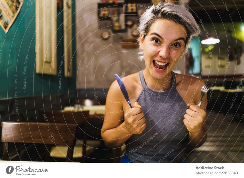 Furious girl posing with silverware Woman Restaurant Appetite having fun Anger Expression facial Emotions humorous hysterical Café Table Adults Stress pretend