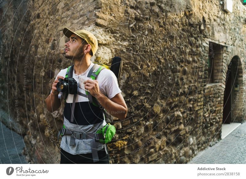 Content traveler enjoying city Man backpacker Street photo camera Old Sightseeing Summer Vacation & Travel Appearance Town Tourist Ancient Vantage point