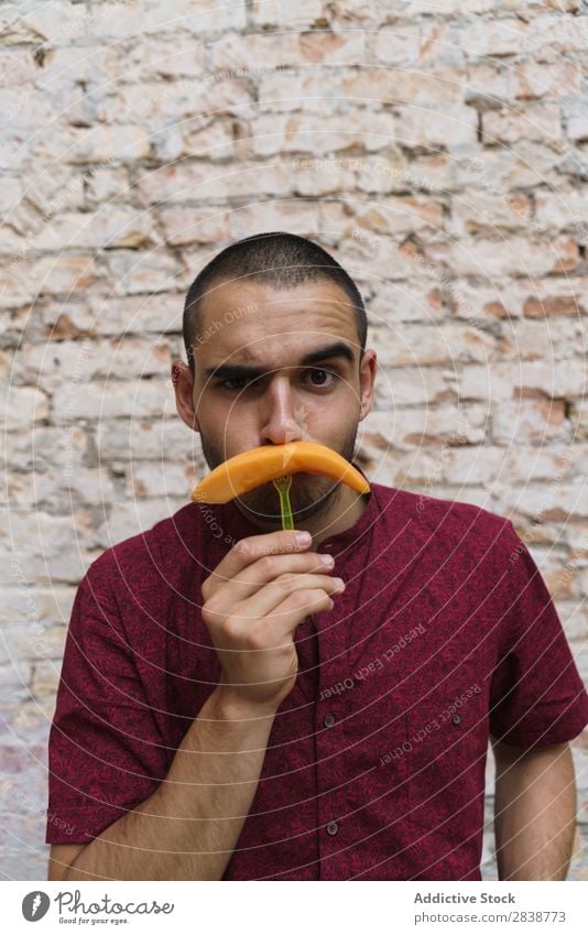 Playful man posing with fruit Man pretend Moustache having fun Fruit Replication Posture Melon Comic Humor Street Joke Youth (Young adults) Slice Grimace Joy