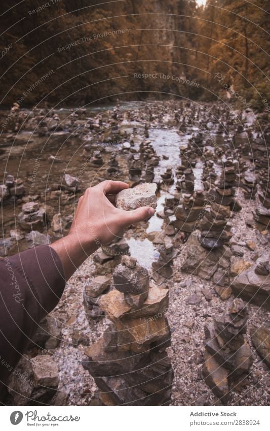 Hand building stone tower Human being Stone Tower Balance Nature Stability Stack Pebble Meditation Relaxation Rock Pyramid Zen Natural Harmonious tranquil Scene