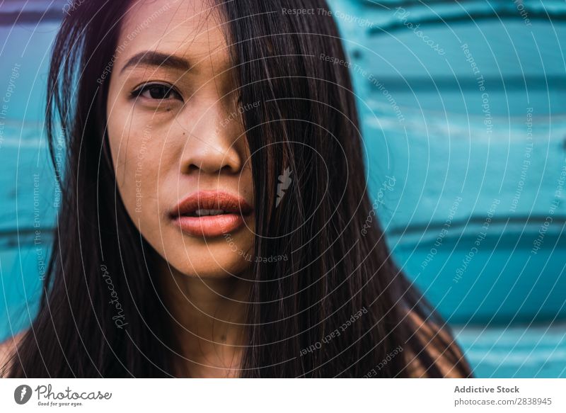 Thoughtful Asian woman leaning on blue door Woman pretty asian Youth (Young adults) Considerate Pensive Cloth Lean Street Town Beautiful Portrait photograph