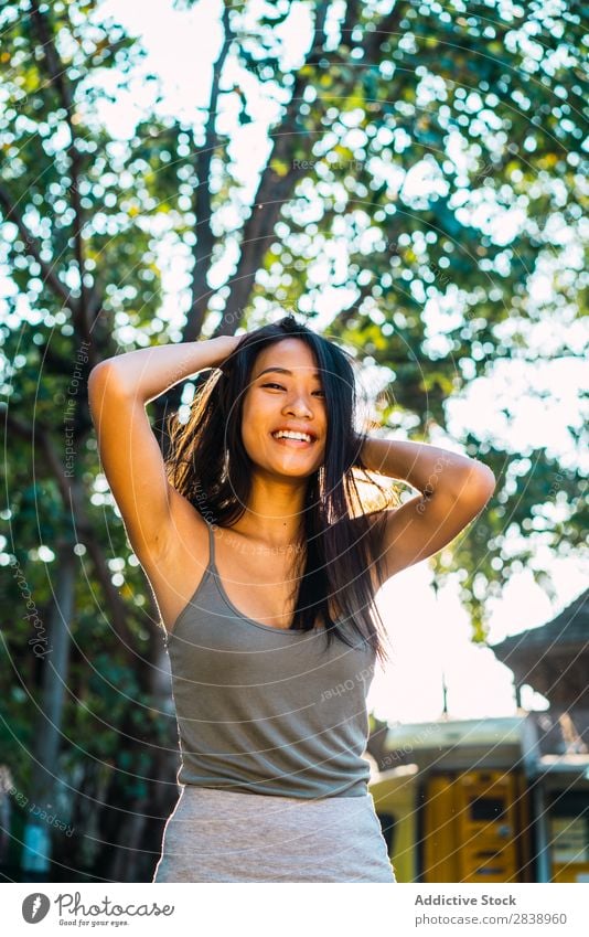 Cheerful Asian woman holding brunette hair Woman pretty asian Youth (Young adults) Smiling Happy holding hair Joy Park Town Brunette Beautiful