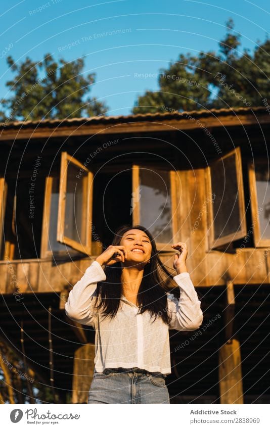 Pretty woman posing near house Woman pretty asian Youth (Young adults) Hair Brunette Joy Wood House (Residential Structure) Sunbeam Beautiful