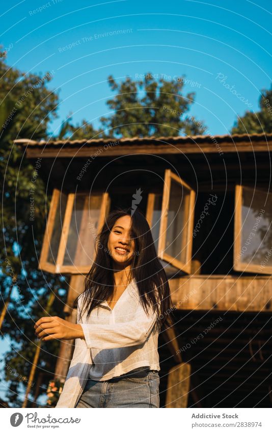 Pretty woman posing near house Woman pretty asian Youth (Young adults) Hair shaking Brunette Joy Wood House (Residential Structure) Sunbeam Beautiful