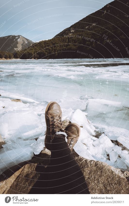 Tourist relaxing at snowy river Human being Legs River Ice Stone Winter Hill Mountain Snow Landscape Nature White Seasons Cold Vacation & Travel Forest Frost