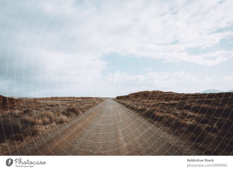 Empty road in dry field Street Nature Dry Landscape Vacation & Travel Desert Landing Grass Sand Ground Environment Yellow Stone Wilderness Beautiful Natural