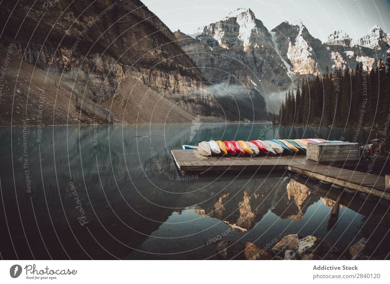 Boats on pier at lake Lake Watercraft Jetty Nature Green Vantage point Mountain Hill Cliff Rock Plant Beautiful Natural Row Seasons Fresh Environment Forest