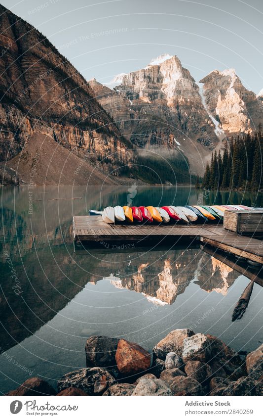 Pier with boats in mountains. Lake Moraine Jetty Watercraft Mountain Reflection Vacation & Travel Tourism Landscape Idyll Calm Transport Vantage point Morning