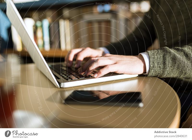 Hands of a man typing on the laptop in a cafe. Horizontal indoors shot. hands communication browsing person businessman device computer male handsome technology