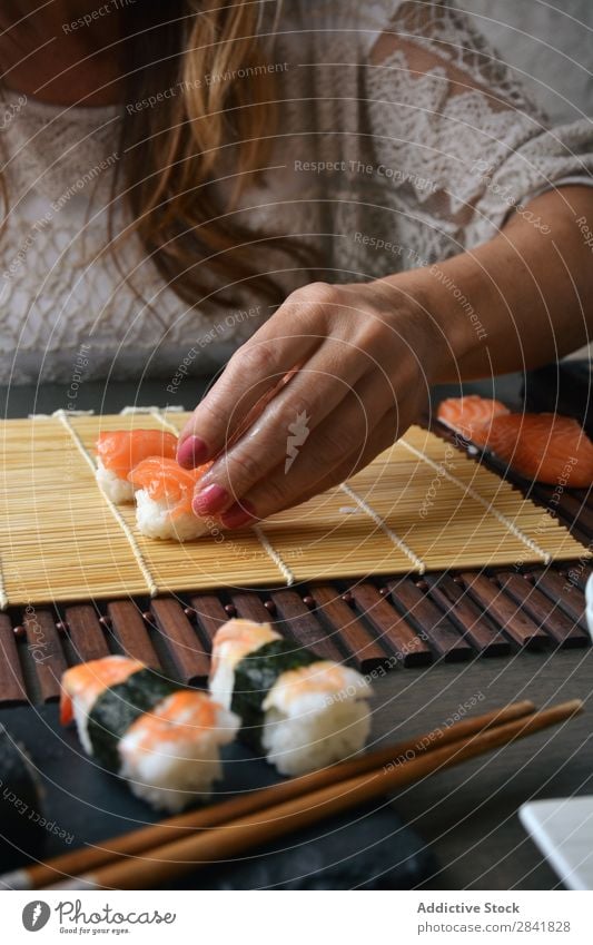 Woman preparing sushi rolls at home Sushi Make Hand Food Rice Preparation maki Chopstick oriental Cooking Mat Seaweed Roll Gourmet Seafood chef East Cucumber