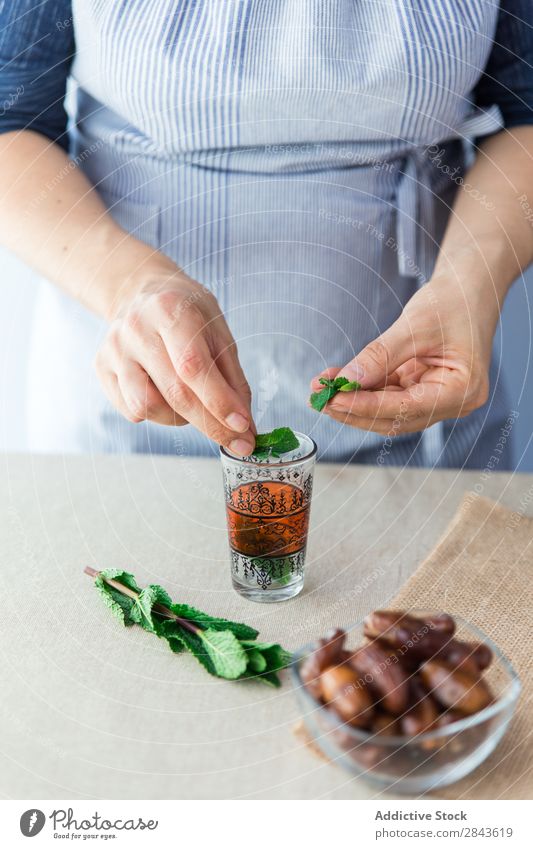 Crop cook putting leaves in small glass Cook Mint Ingredients Fragrant Organic Cooking Fresh herbal Green Aromatic Leaf Healthy Plant peppermint spearmint