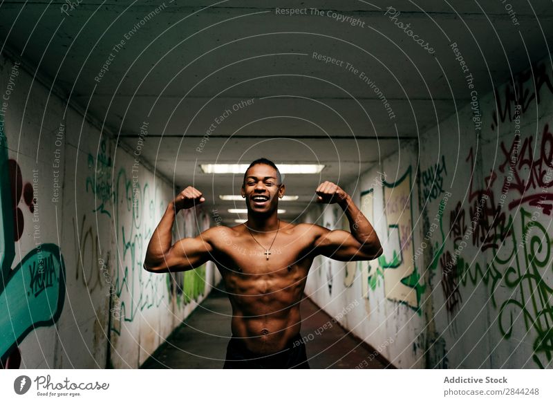 Cheerful sportsman posing underground Man grungy Athletic Musculature Indicate shirtless Sports African Graffiti Underground handsome Torso Model Body Posture