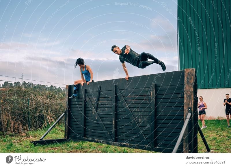 Participants in obstacle course climbing wall Lifestyle Sports Climbing Mountaineering Human being Woman Adults Man Group Jump Authentic Strong Effort Energy