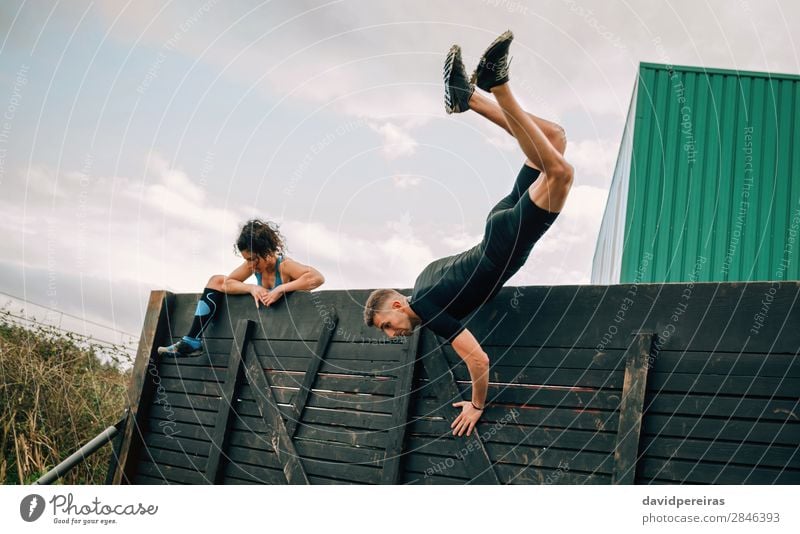 Participants in obstacle course climbing wall Lifestyle Sports Climbing Mountaineering Human being Woman Adults Man Jump Authentic Strong Effort Energy