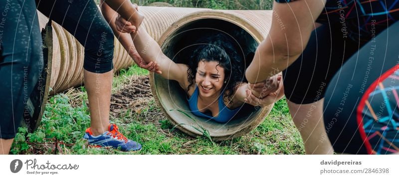 Woman in obstacle course going through pipe Sports Internet Human being Adults Group Tube Strong Effort Competition Teamwork pulling obstacle course race crawl