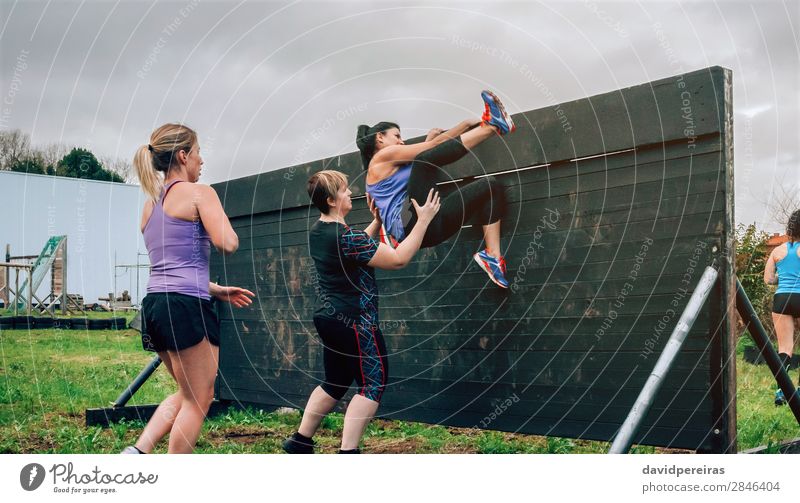 Participants in obstacle course climbing wall Lifestyle Sports Climbing Mountaineering Human being Woman Adults Group Authentic Strong Effort Competition