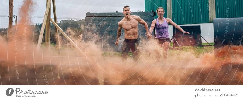 Couple jumping tires at finish line of obstacle course Happy Sports Success Internet Human being Woman Adults Man Jump Competition Teamwork athlete Finish line