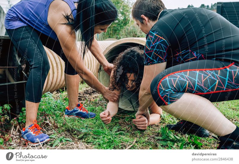 Woman in obstacle course going through pipe Lifestyle Joy Sports Human being Adults Group Tube Authentic Strong Effort Competition Teamwork obstacle course race