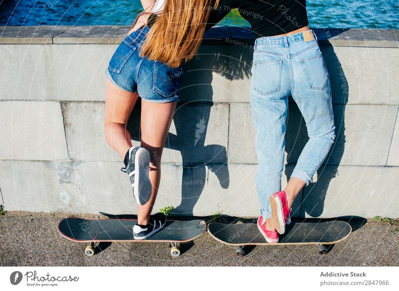 Back view of girls on skates Youth (Young adults) Skateboard Posture Town Summer Girl Sports Hip & trendy Uniqueness Leisure and hobbies Easygoing Skateboarding