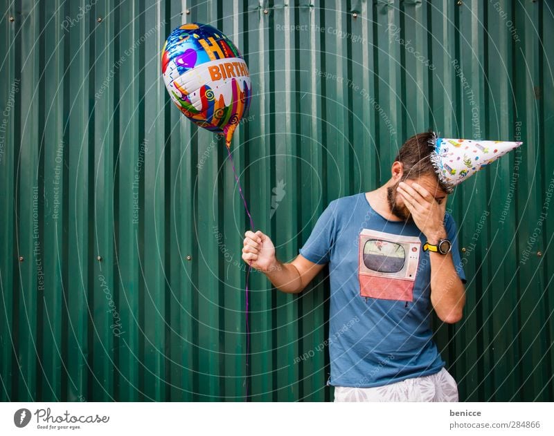 Getting older Birthday Human being Man Youth (Young adults) Young man Old Balloon party hat Wall (building) Cry Disappointment Sadness Tears To hold on Green