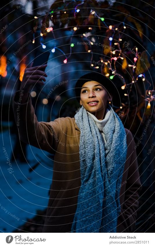 Woman taking selfie near tree with lights Selfie Light Beautiful Youth (Young adults) Portrait photograph Human being Tree PDA Easygoing Mobile Smiling pretty