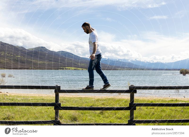 Man balancing on fence Fence Balance Walking Lake Wood Rural Landscape Adults Human being Risk Lanes & trails Surface Holiday season Dangerous Nature Tourism