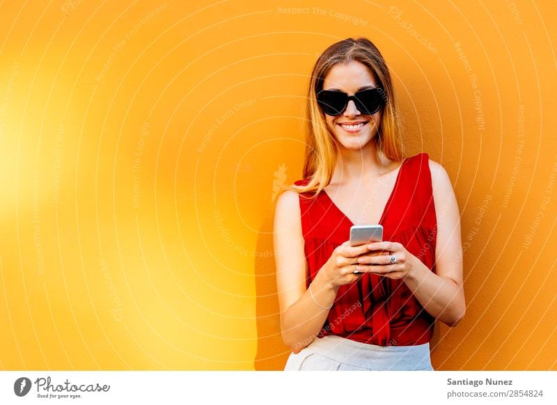 Portrait of beautiful young woman using mobile phone in the street. Woman Telephone Happy Mobile Youth (Young adults) Wall (building) Cellphone