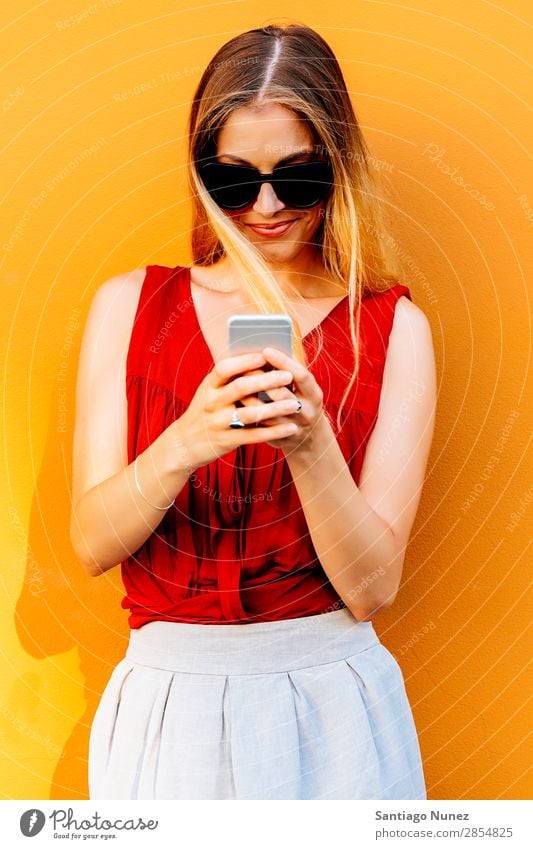 Portrait of beautiful young woman using mobile phone in the street. Woman Telephone Happy Mobile Youth (Young adults) Wall (building) Cellphone