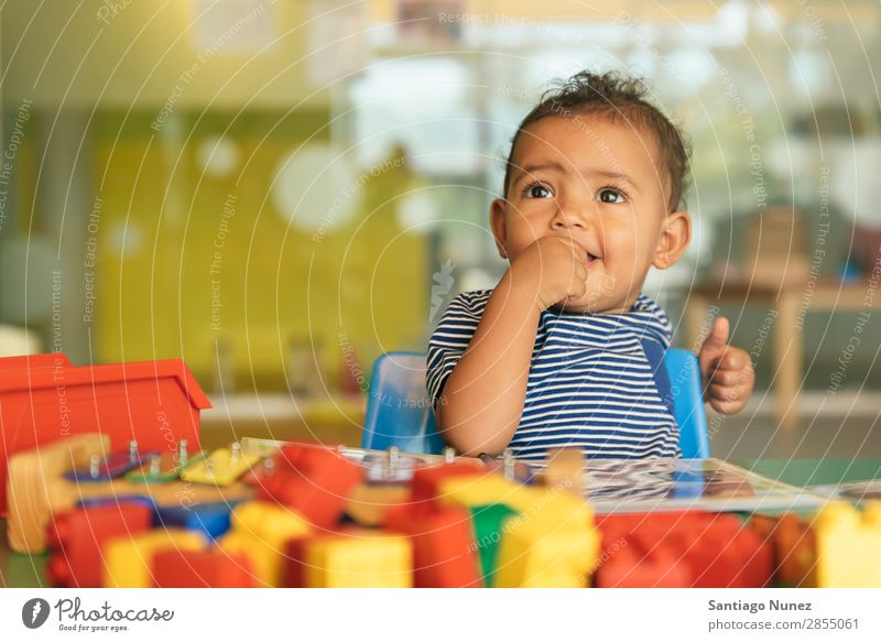 Happy baby playing with toy blocks. Baby Playing childcare Kindergarten School Toys Toddler Girl Small Child Smiling Considerate Cute Joy Preschool Education