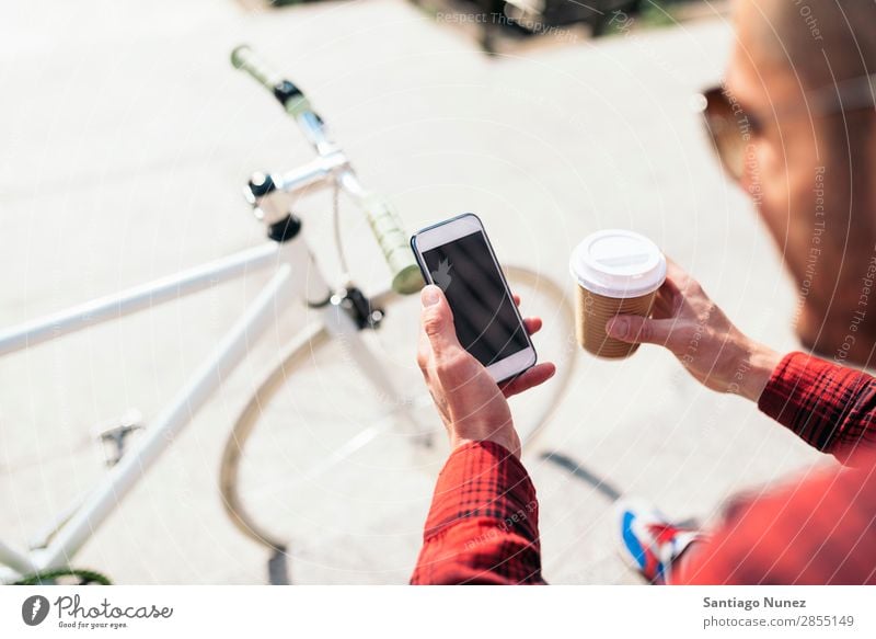 Young man using his mobile in the street. Mobile Man Portrait photograph Happy Smiling Telephone Hipster Lifestyle Stand City Solar cell Town Human being