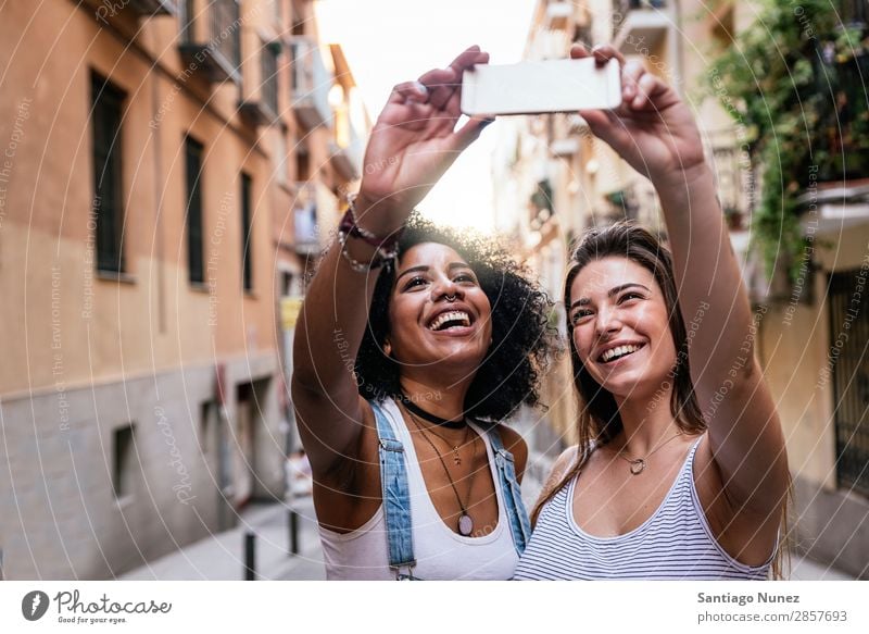 Beautiful women taking a self portrait in the Street. Woman Friendship Youth (Young adults) Happy Summer Human being Joy Mobile PDA Telephone Solar cell