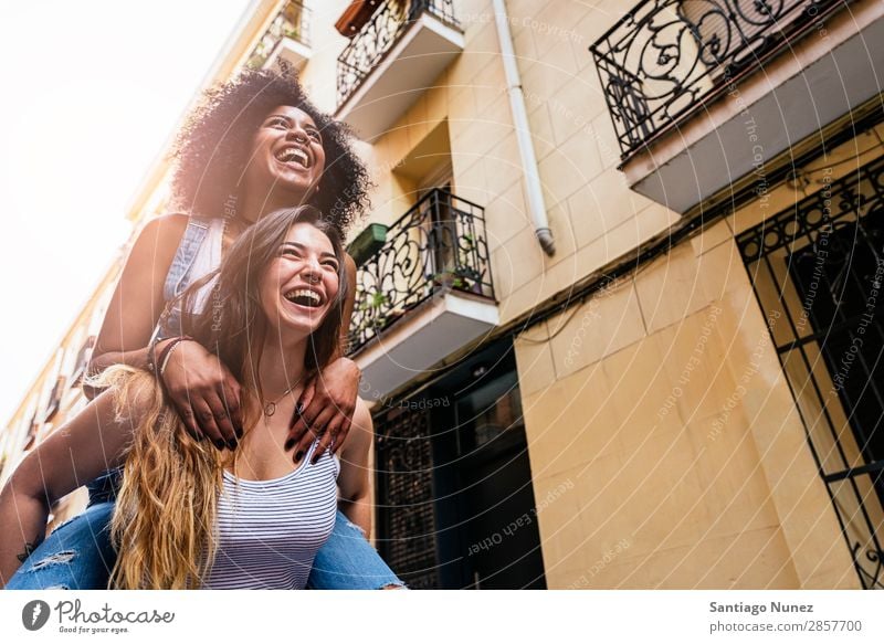 Beautiful women having fun in the street. Woman Friendship Youth (Young adults) Happy piggybacking Smiling Summer Human being Joy Walking Girl pretty 2 Together