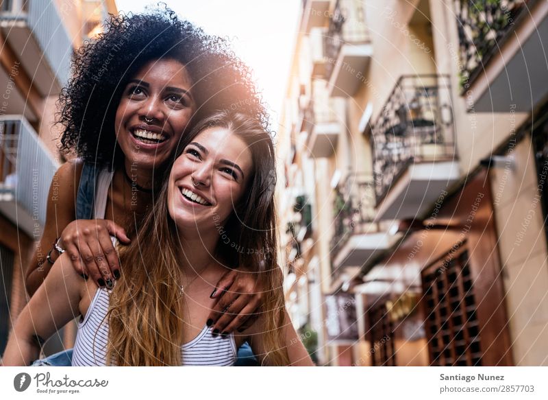 Beautiful women having fun in the street. Woman Friendship Youth (Young adults) City Happy piggybacking Smiling Summer Human being Joy Walking Girl pretty 2