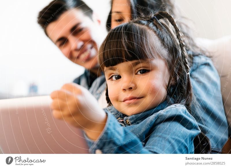 Happy family using tablet. Family & Relations Tablet computer Parents Computer Digital Home Youth (Young adults) Child Education Couch Sit Cheerful Smiling