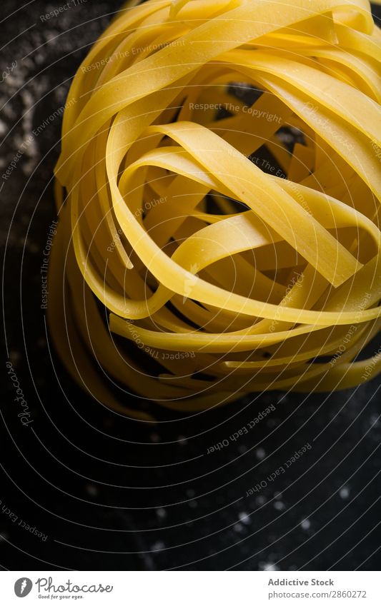 Raw tagliatelle on dark table Background picture Blackboard Board carbohydrate Close-up Dough Dry Egg Flour Food Fresh Healthy Home-made Italian Kitchen