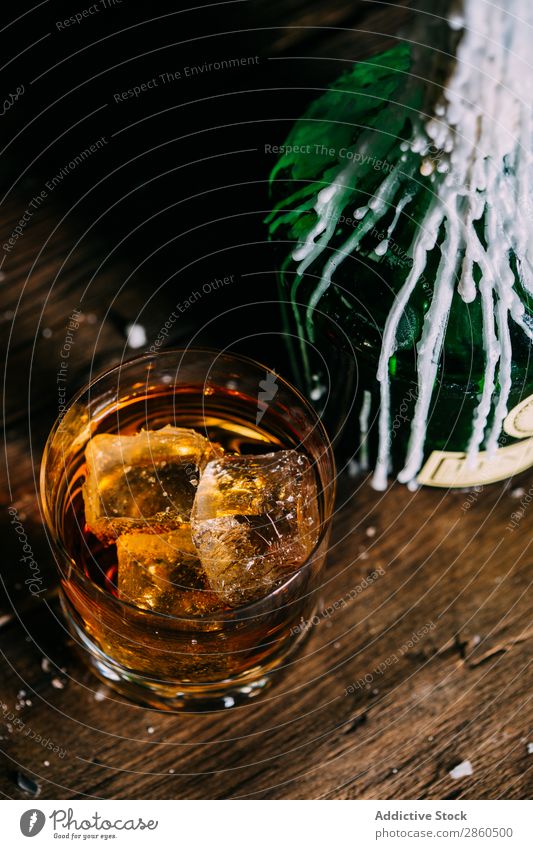 Glass of whiskey on a wooden table Alcoholic drinks Amber Background picture Bar barman bartender Beverage Bottle Bourbon Brandy Cognac Drinking Gold Hand Ice