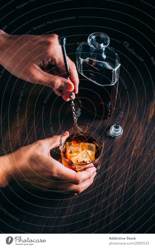 Glass of whiskey on a wooden table Alcoholic drinks Amber Background picture Bar barman bartender Beverage Bottle Bourbon Brandy Cognac Drinking Gold Hand Ice